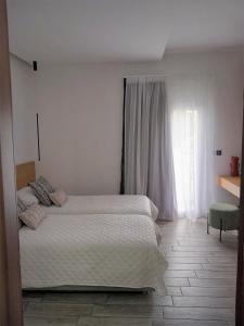 um quarto com uma cama grande e uma janela em Bianco Hotel em Lakkíon
