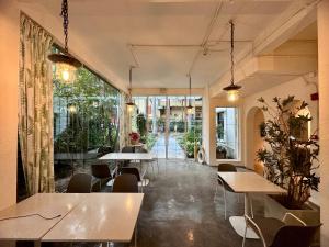 a restaurant with tables and chairs and a large window at Shenzhen Loft Youth Hostel in Shenzhen