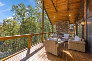 a screened in porch with chairs and a stone fireplace at Angels Share in Seven Devils