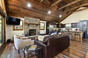a living room with leather furniture and a stone fireplace at Angels Share in Seven Devils