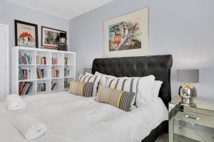 - une chambre avec un grand lit blanc et une tête de lit noire dans l'établissement Deco Seafront - By My Getaways, à Brighton et Hove