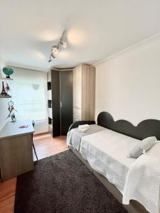 a bedroom with two beds and a desk in it at Apartamento Praia Naval in Isla de Arosa