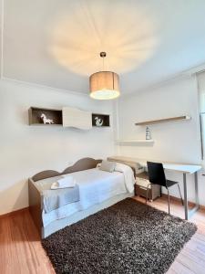 sypialnia z łóżkiem i biurkiem w obiekcie Apartamento Praia Naval w mieście Isla de Arosa