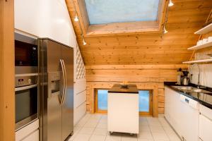 uma cozinha com um frigorífico de aço inoxidável e paredes de madeira em Stora Björnrike em Vemdalen