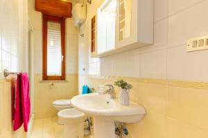 - une salle de bains blanche avec lavabo et 2 toilettes dans l'établissement Appartamento Alide Bilo 1P - MyHo Casa, à Tortoreto Lido