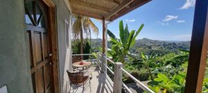 a balcony of a house with a table and chairs at Tranquility with Stunning View in Morne Jaloux Ridge