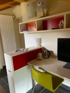 oficina con escritorio con ordenador y silla amarilla en Small apartments in Collina d’Oro, en Agra