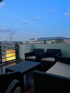 einen Balkon mit Tischen und Stühlen und Stadtblick in der Unterkunft Inside Room Inn in Tagum