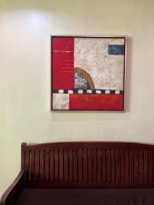 a painting hanging on a wall next to a bench at Inside Room Inn in Tagum