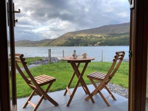 een tafel en 2 stoelen met uitzicht op een meer bij Sunset POD in Dunan