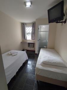Cette chambre comprend 2 lits et une télévision murale. dans l'établissement BIGS HOTEL, à Penápolis