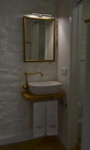 a bathroom with a sink and a mirror on the wall at Casa do Theatro Guest House in Barcelos