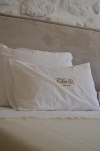 a bed with two white pillows on top of it at Casa do Theatro Guest House in Barcelos