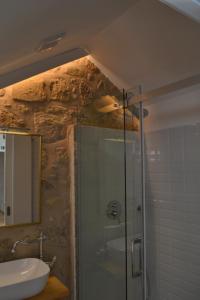 a bathroom with a glass shower and a sink at Casa do Theatro Guest House in Barcelos