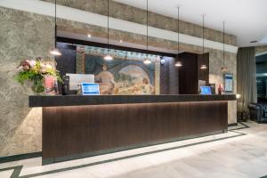 a lobby with a reception desk with a painting on the wall at Castilla Termal Solares in Solares