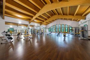 a gym with treadmills and machines in a large room at Castilla Termal Solares in Solares