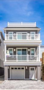 a large white house with a balcony and two garage doors at Cora's Beach Club in Seaside Heights
