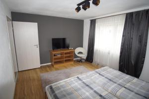 1 dormitorio con 1 cama y TV en Fewo Nüßle, en Bad Grönenbach