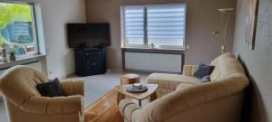 a living room with two couches and a tv at Moderne120qm Ferienwohnung in ruhiger Lage Heusweiler - Saarland in Heusweiler