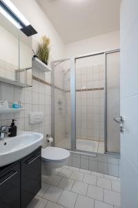 La salle de bains est pourvue d'un lavabo, de toilettes et d'une douche. dans l'établissement SweetHome - Zentral - Küche & Parkplatz, WiFi, à Halle-sur-Saale