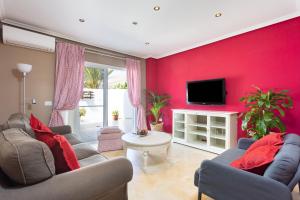 un soggiorno rosso con 2 divani e una TV di Home2Book Comfy Apt Puertito de Güímar, Pool a Puertito de Güímar