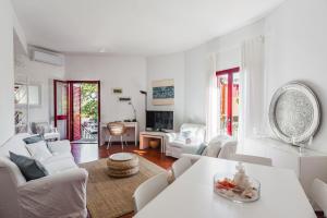 een woonkamer met witte meubels en een tafel bij Casa Magnolia by Wonderful Italy in Aci Castello