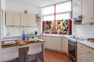 uma cozinha com armários brancos e uma janela em Casa Magnolia by Wonderful Italy em Aci Castello