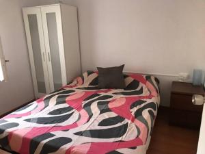 1 dormitorio con 1 cama con un edredón colorido en Premia de Mar, Maresme, Barcelona, en Premiá de Mar