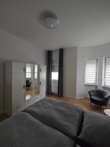 1 dormitorio con 1 cama grande y 1 silla en Ferienwohnung Schöne Aussicht, en Zell an der Mosel