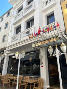 un hotel con mesas y banderas delante en MORAVA HOTEL en Estambul