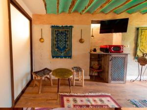 uma sala de estar com uma mesa e cadeiras num quarto em Domus Lapidis - Medina em Bogarra