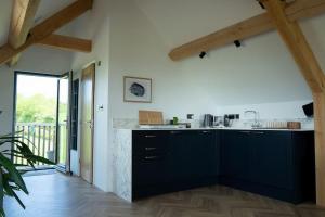 a kitchen with black cabinets and a counter top at Bedport Loft in Burrington