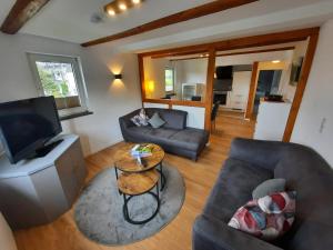 a living room with a couch and a television at Landhaus Gnacke in Schmallenberg