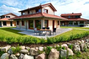 une maison avec une table et des chaises devant dans l'établissement Ferienhaus LebenPUR Bio-Ferienhaus aus Holz, à Parin