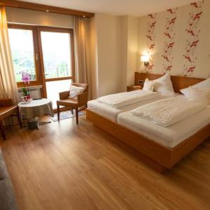 una habitación de hotel con una cama grande y una mesa en Hotel Zehnthof en Ürzig