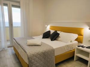 A bed or beds in a room at Hotel Gran San Bernardo - RICCIONE - FRONTE MARE CON CUCINA