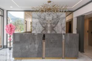 a lobby with a large marble wall with a chandelier at Montenegro Lodge in Tivat