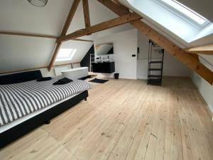 ein Schlafzimmer mit einem Bett und einem Holzboden in der Unterkunft Vakantiehuis Joanitas in Bredene