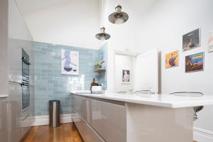 La salle de bains est pourvue d'un comptoir blanc et de carreaux bleus. dans l'établissement Spacious Sillwood Street - Brighton, à Brighton et Hove