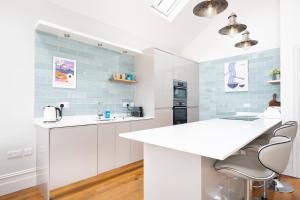 een keuken met witte werkbladen en blauwe tegels bij Spacious Sillwood Street - Brighton in Brighton & Hove