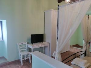 a room with a computer and a desk with a television at SPELLO ROMANTICA in Spello
