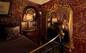 a bedroom with a bed and a large mirror at Prestonfield House in Edinburgh