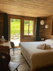 um quarto com uma cama grande e uma janela em Alpen Charme - Chalet d'Hôtes et SPA em Gsteig