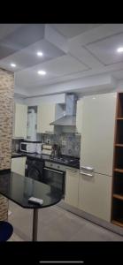 a kitchen with a table and a stove and a refrigerator at Stylish City Apartment in Monastir +4 photos