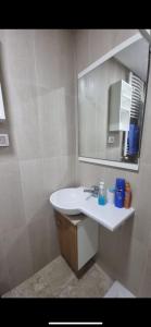 a bathroom with a white sink and a mirror at Stylish City Apartment in Monastir
