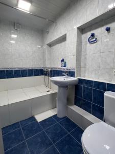 a bathroom with a sink and a tub and a toilet at Red-N House in Tashkent
