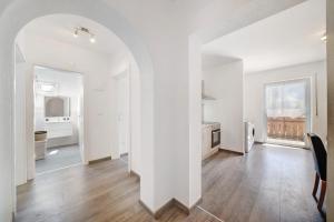an open living room with white walls and wooden floors at Haus Tanja Apartment 3 in Parcines