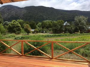 a wooden deck with a view of a mountain at Chacra confluenza in Lago Puelo