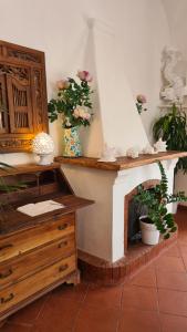 a room with a fireplace and a desk with flowers at Casa Bon Bon in Positano