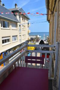 d'un balcon avec deux chaises et une vue sur l'océan. dans l'établissement La Petite Baleine, appt à 50m de la plage, à Luc-sur-Mer